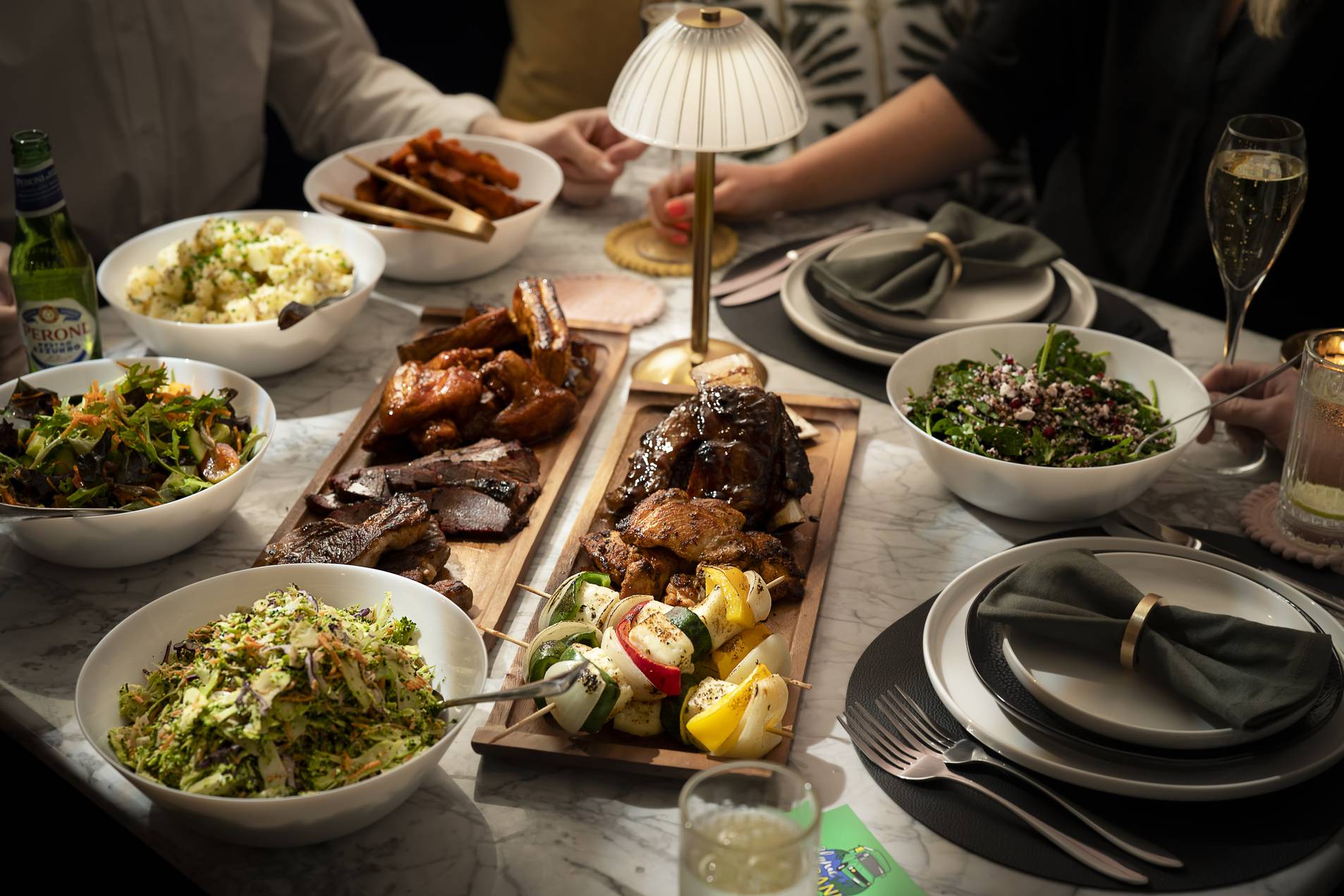 Sharing boards of barbecued meats, skewers and sides down the middle of a wedding table