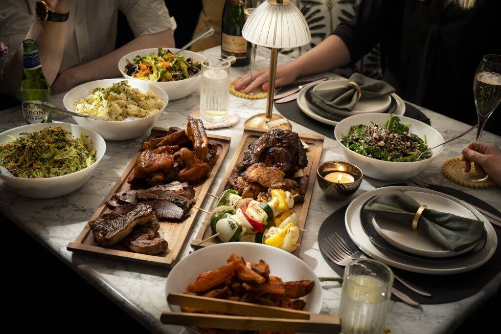 Boards of barbecued ribs, chicken and lamb with salads at a wedding table