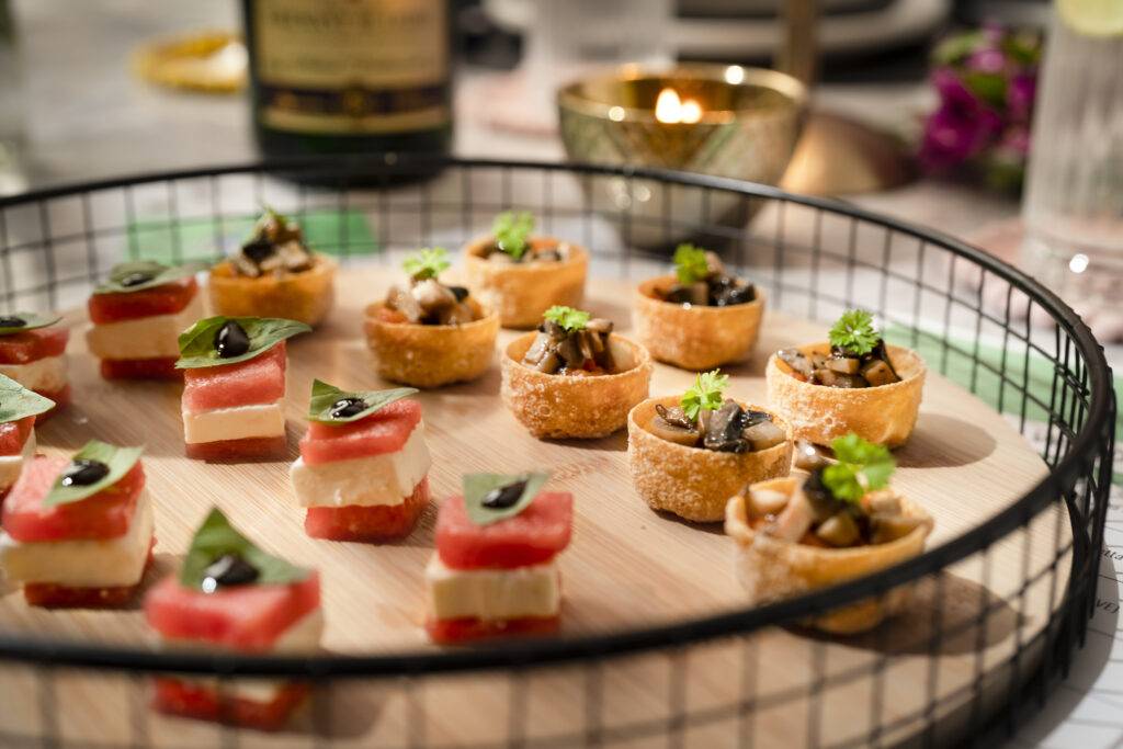 Blame Frank canapes, watermelon and feta bites and filled pastry cups on a wooden board